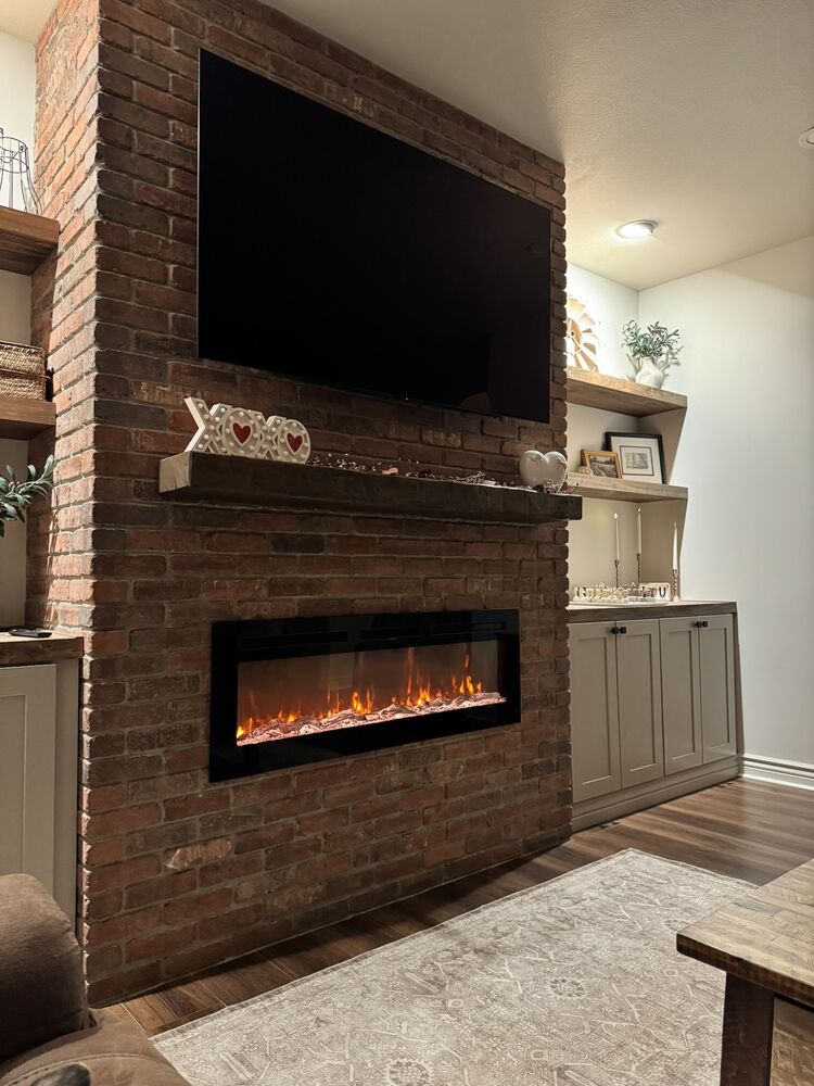 Living room with brick fireplace wall and built-in shelving
