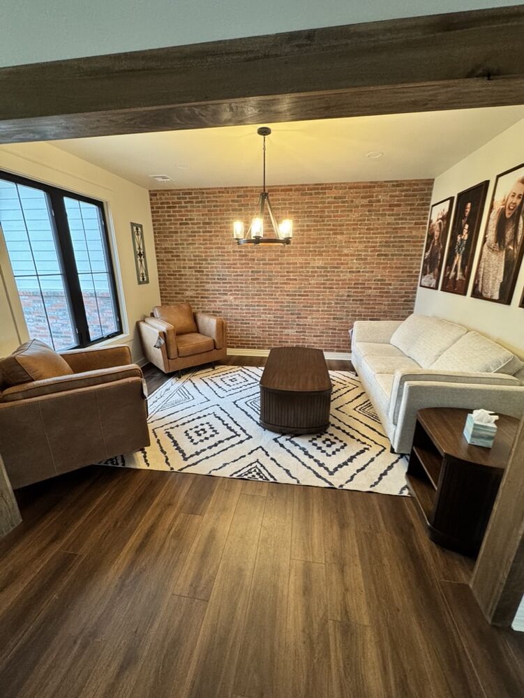 Living room with brick accent wall and leather seating