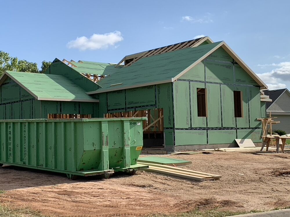 New Tallgrass build, wall sheathing wrapped with dumpster staged
