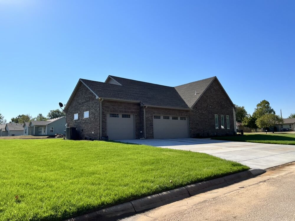 New Tallgrass custom home build, side exterior with three-car garage